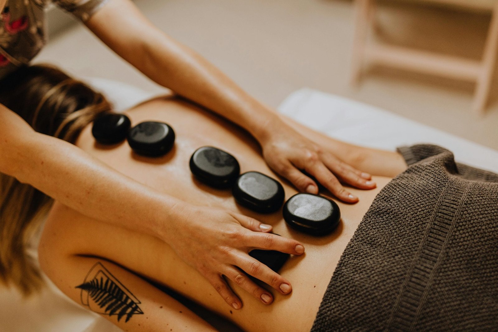 white woman having a hot stone massage on a massage table